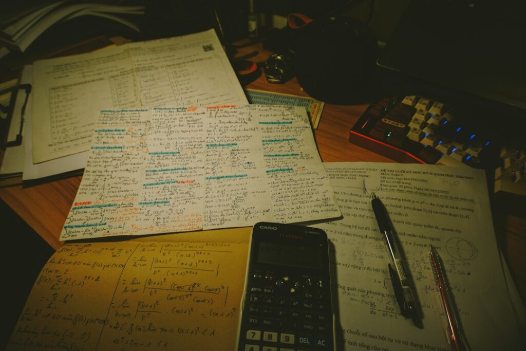 Exam papers, calculator and pens on a study desk