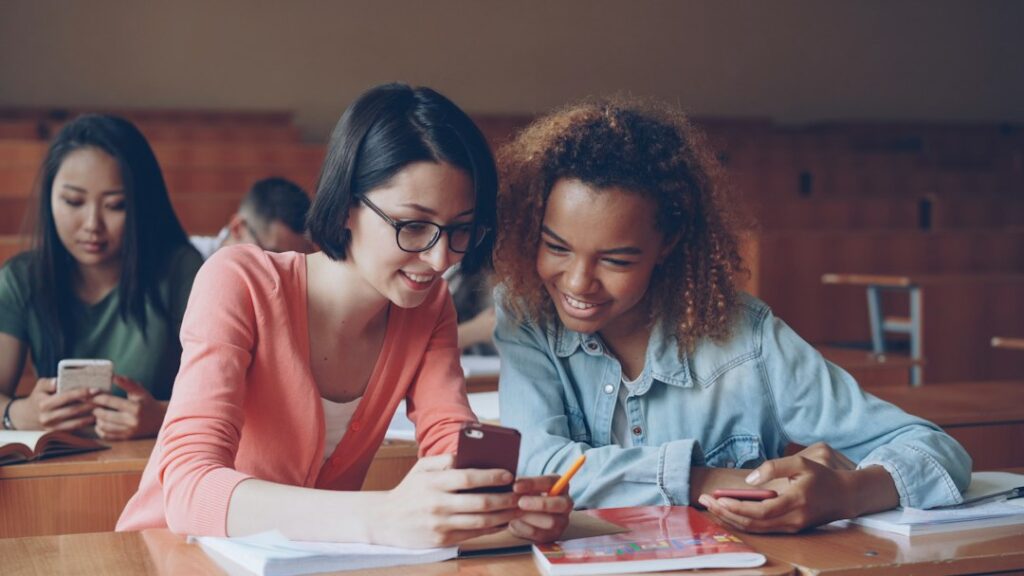 Two students checking their exam result on a smartphone
